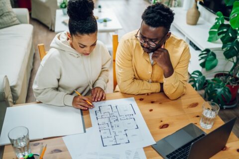 Two people looking at design blueprints by We Do Kitchens 2