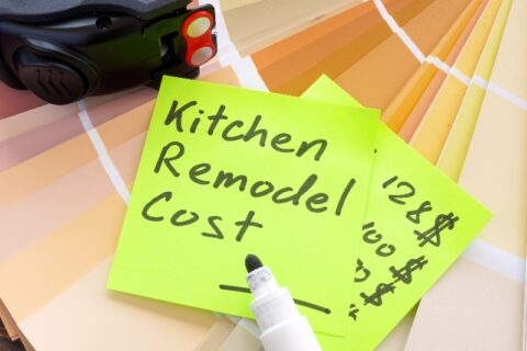 Kitchen remodel cost written on a sticky note on top of paint chips by We Do Kitchens 2